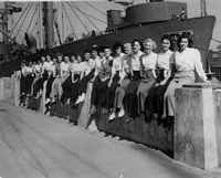 Women pose beside a ship they helped build during World War II.