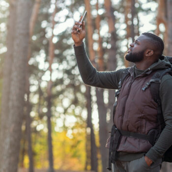 man on phone in woods with wireless carriers helping RVers