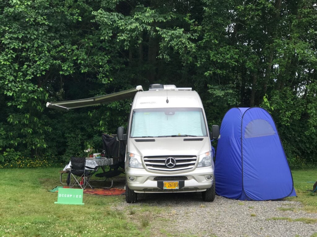 Mercedes camper van set up at campsite.