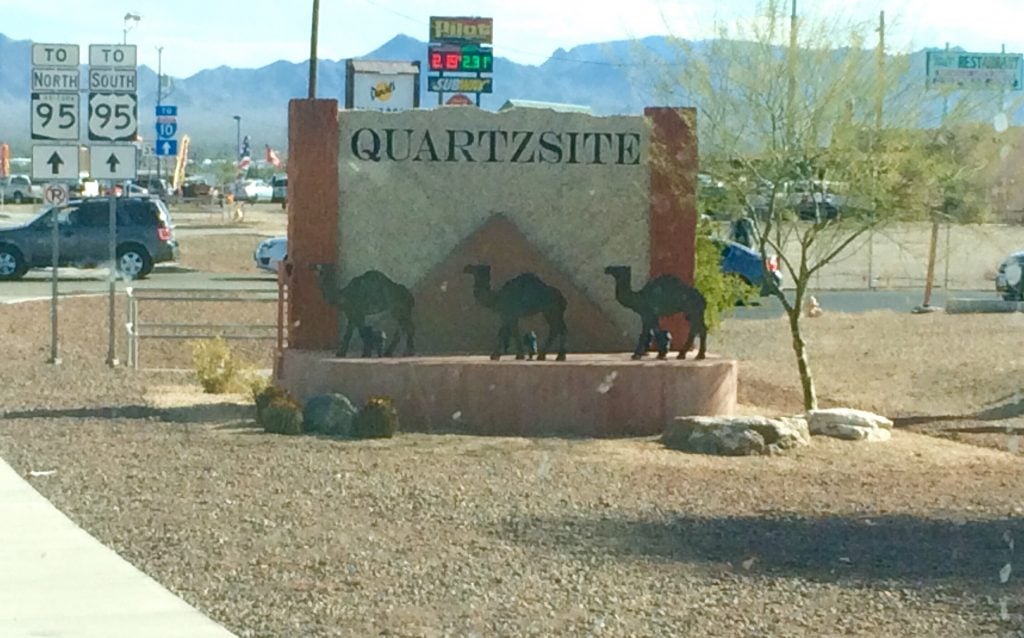 Sign entering Quartzite, AZ with three camel cutouts 