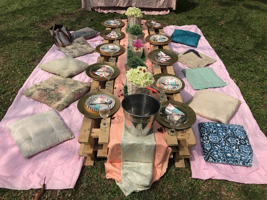 Table setup outside with pillows for seats and pallet board for the table. Eating outside is great when you've done all the RV cooking. 