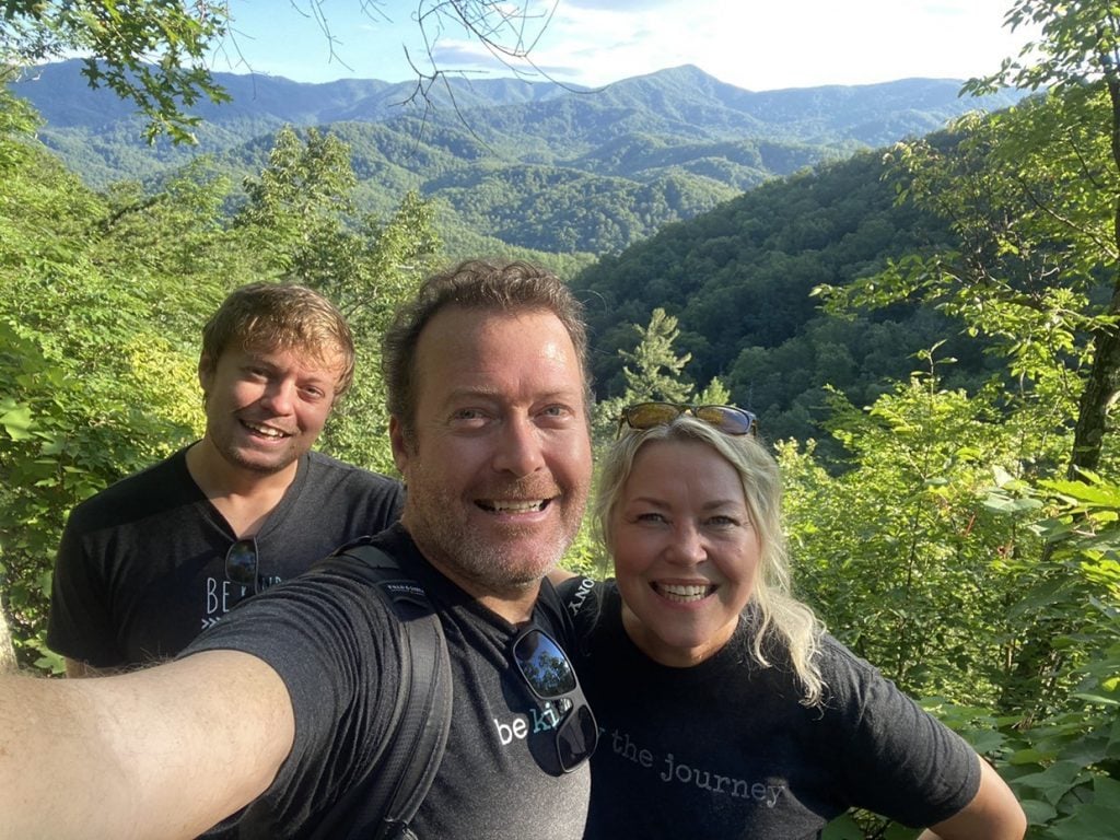 RV bloggers taking a selfie in front of a beautiful mountain backdrop