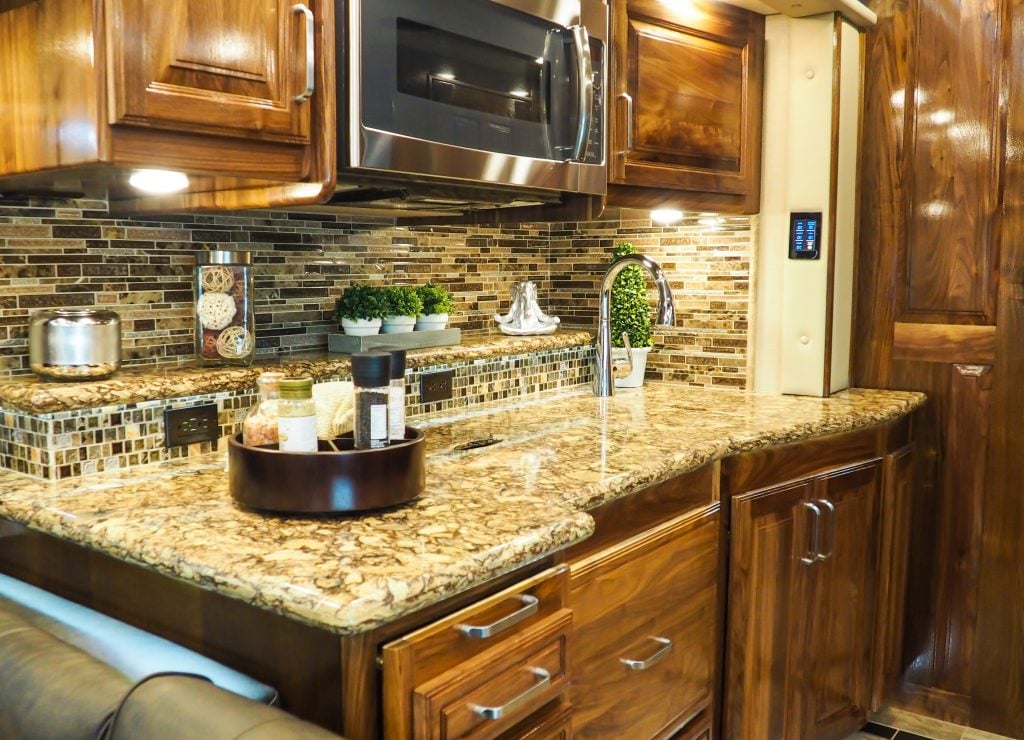 Interior of a class A RV showing a large countertop with decorations setup. 