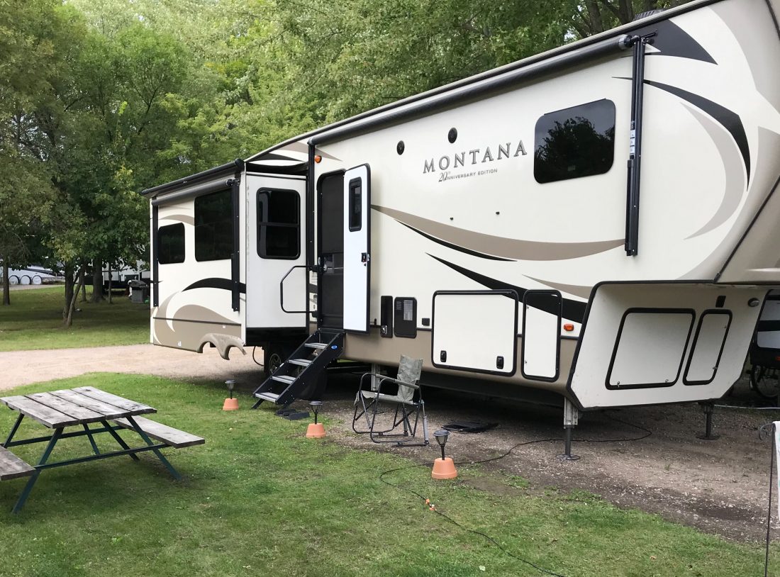 Montana fifth wheel RV parked with green grass and picnic table