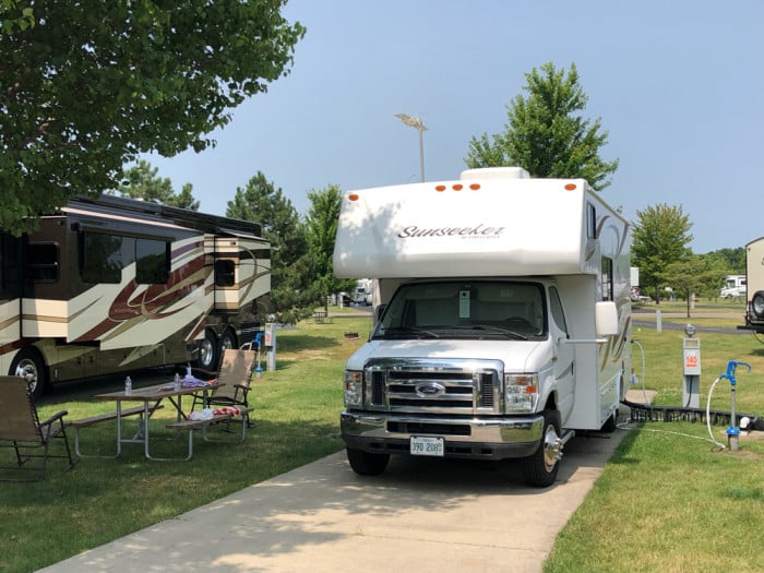 White Class C RV on a cement pad with Class A in the background - RV parks in Michigan
