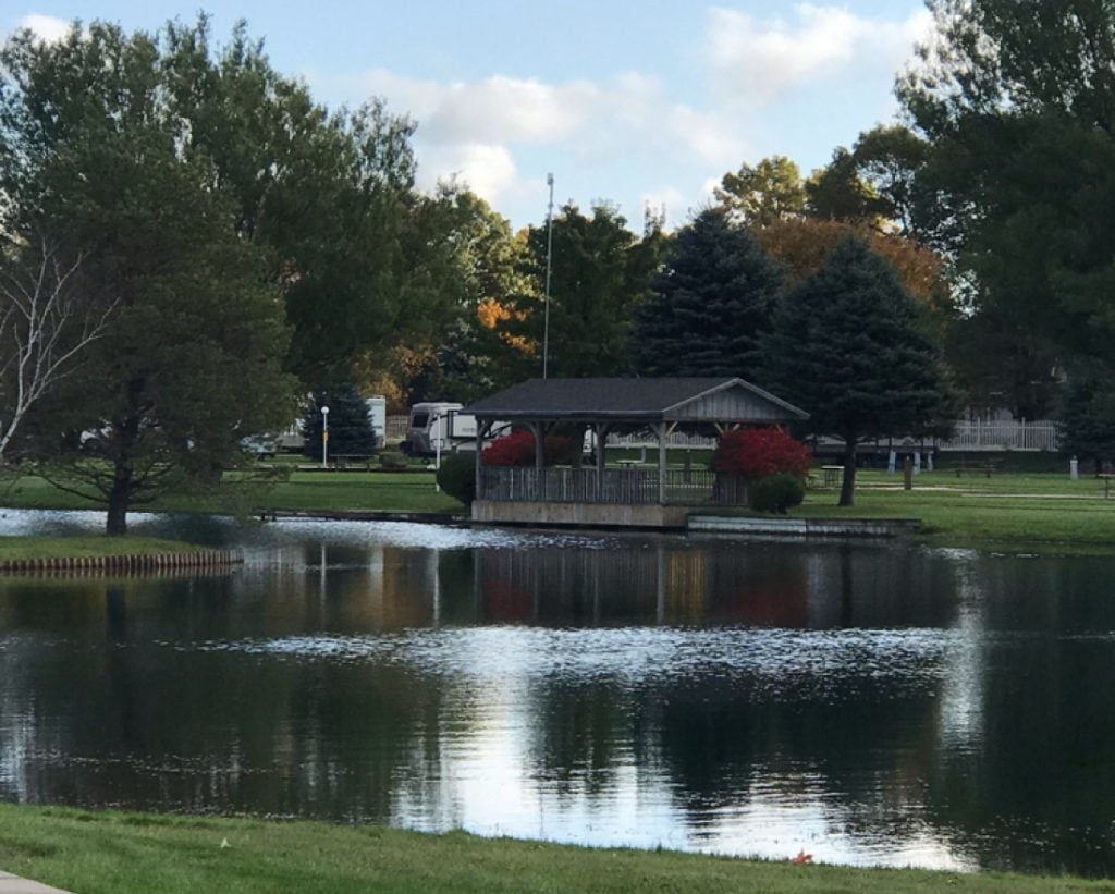 Light reflecting off a pond with trees and a fishing dock in the background - view from RV parks in Michigan