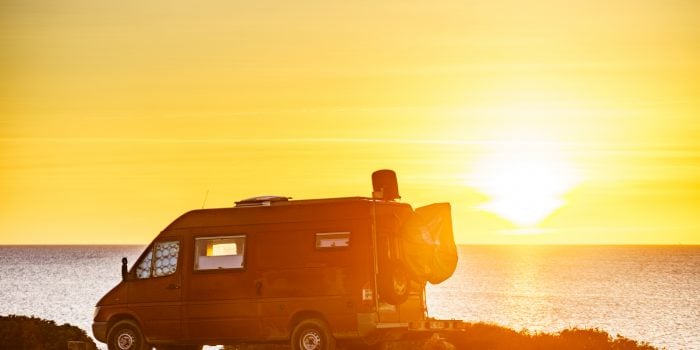 Camper van on the beach at sunset.