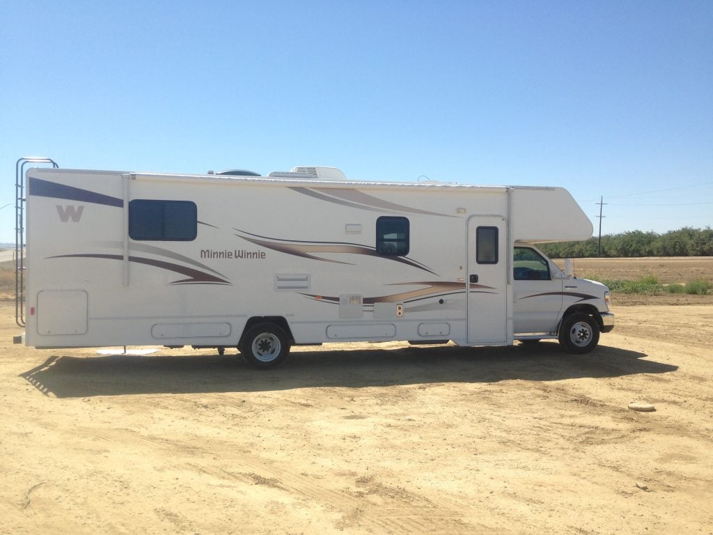 Large Class C RV parked in a dirt lot 