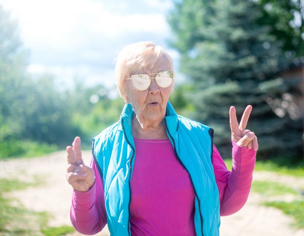 An older woman making a funny face and giving the peace sign at an RV summit