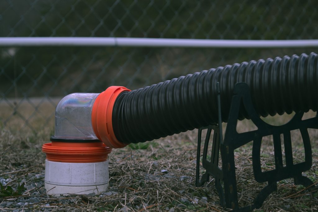 RV sewer hose connected to sewer outlet. You'll want to know how to connect sewer when it comes to how to set up a campsite