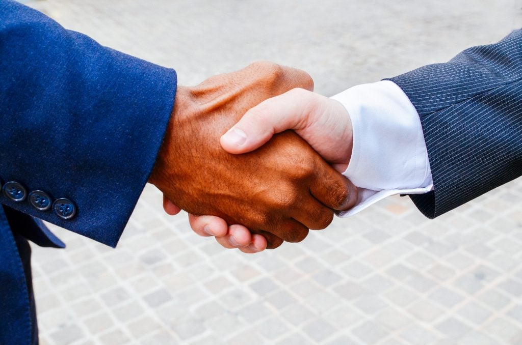 Two men shaking hands after one of them got approved for RV financing for full timers.
