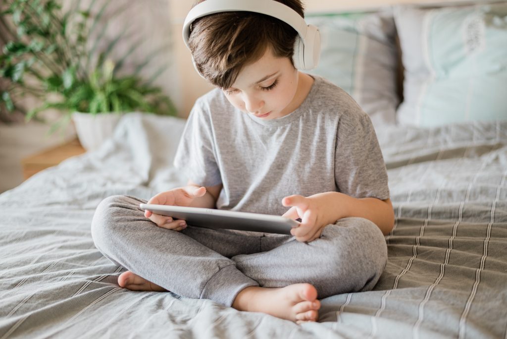 a little boy on an iPad with his headphones on