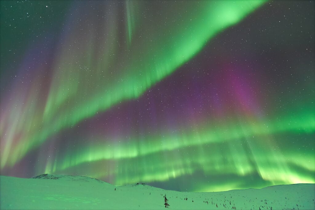 The aurora borealis in Alaska. People want to know can you drive an RV to Alaska to see this natural wonder. 