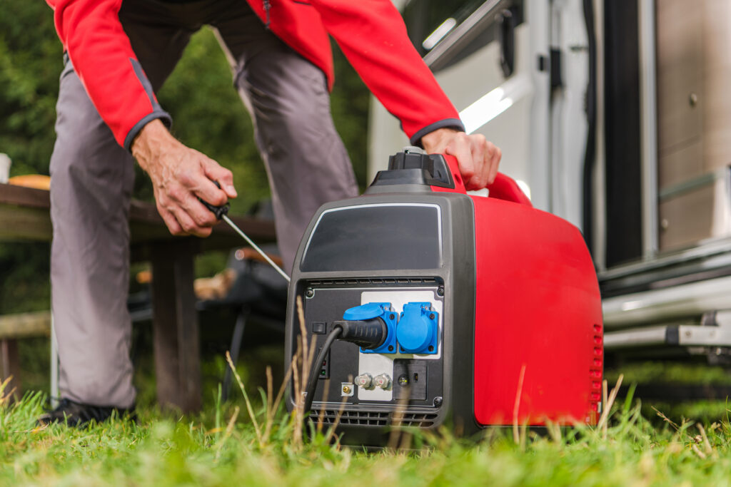 A man bent over starting his portable generator to use for RV boondocking power