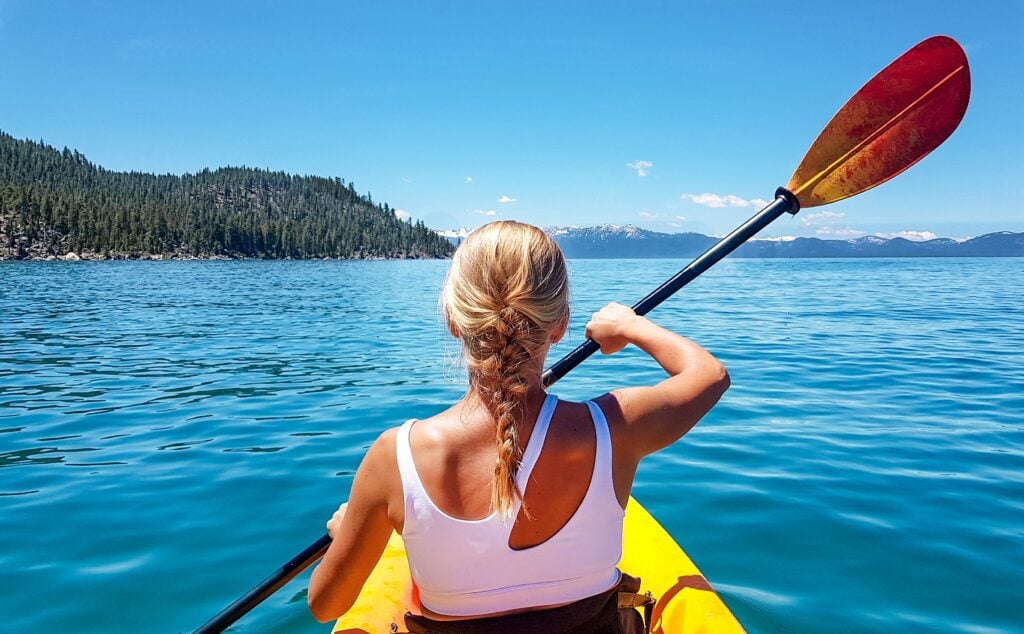 A woman in a kayak on her lake Tahoe camping trip 