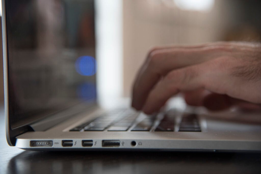 A man holding his hands over a laptop keyboard 