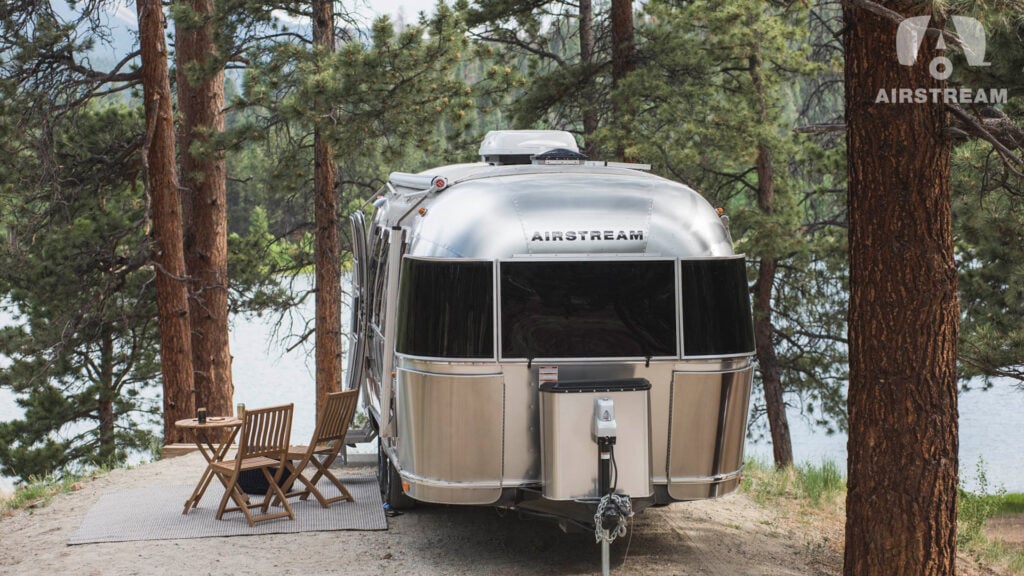 An Airstream parked in a wooded campsite