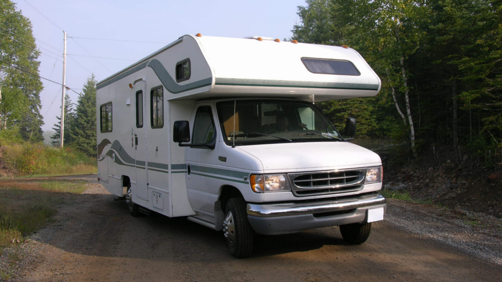 An older RV parked in a dirt road. A used RV could be the best RV for full-time living depending on your budget. 