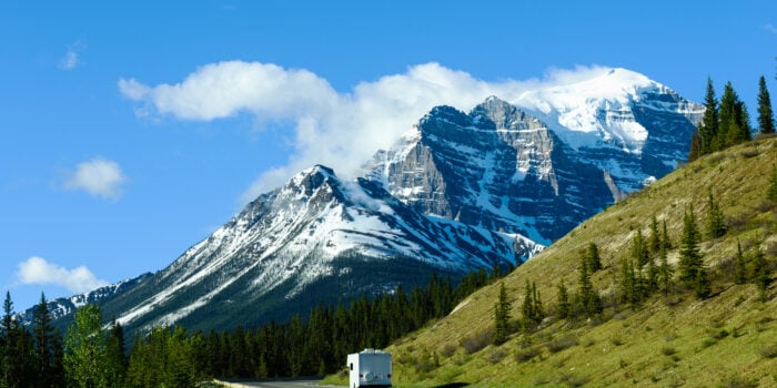An RV travels on a scenic highway in Canada.