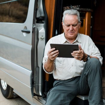 Older RVer choose RV warranty protection on his tablet inside his RV