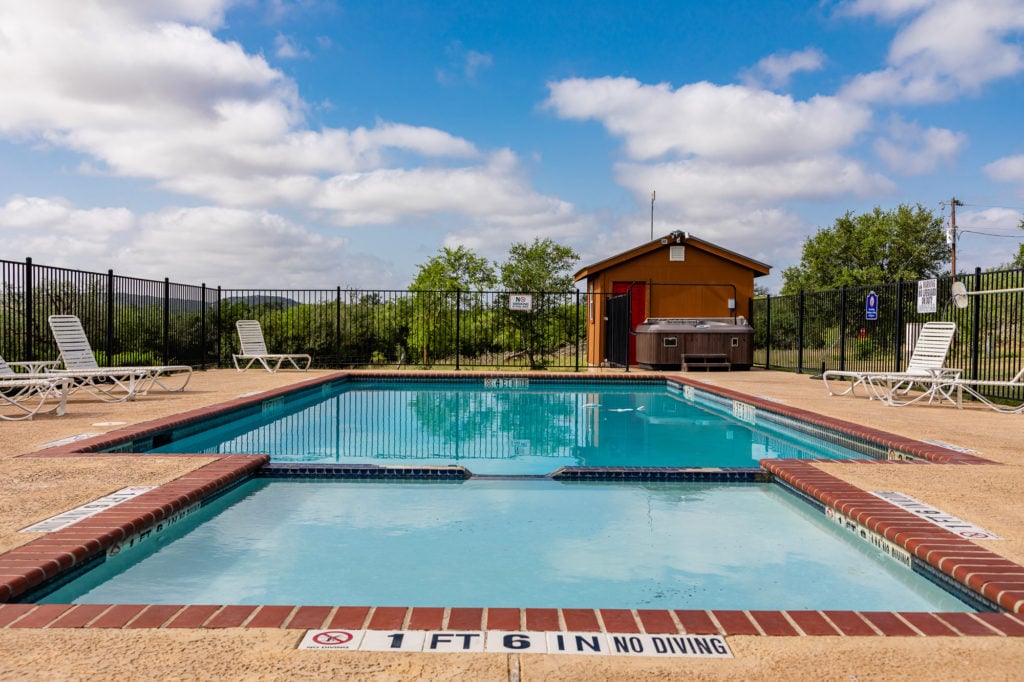 Pool and hot tub area with a wooded background - Kerrville RV parks