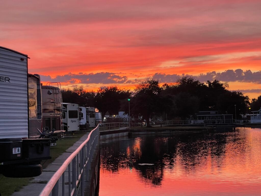 beautiful sunset in an RV park reflected in the pond 
