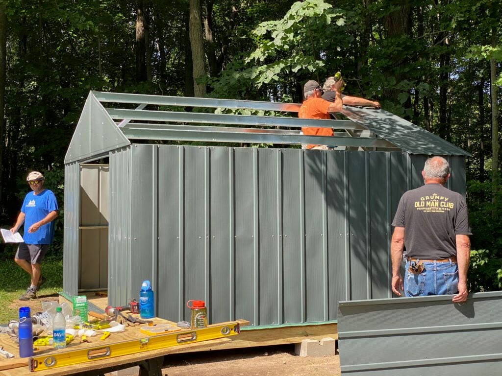Men put together a sheetmetal shed