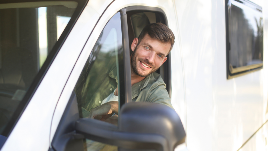 A man in an RV looking out the driver's window after buying an RV for the first time