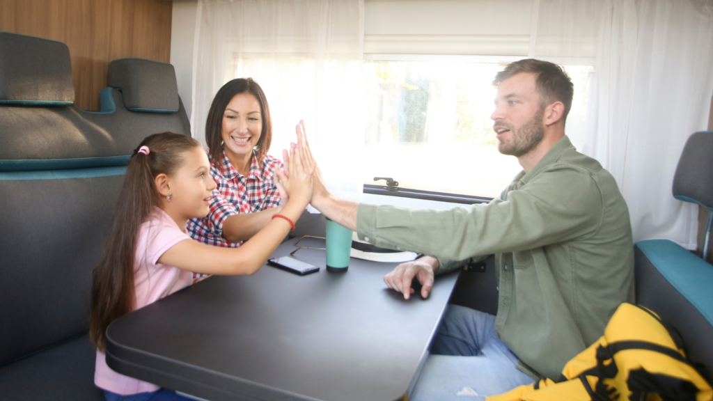 A family sitting in an RV with a little girl talking about roadschooling