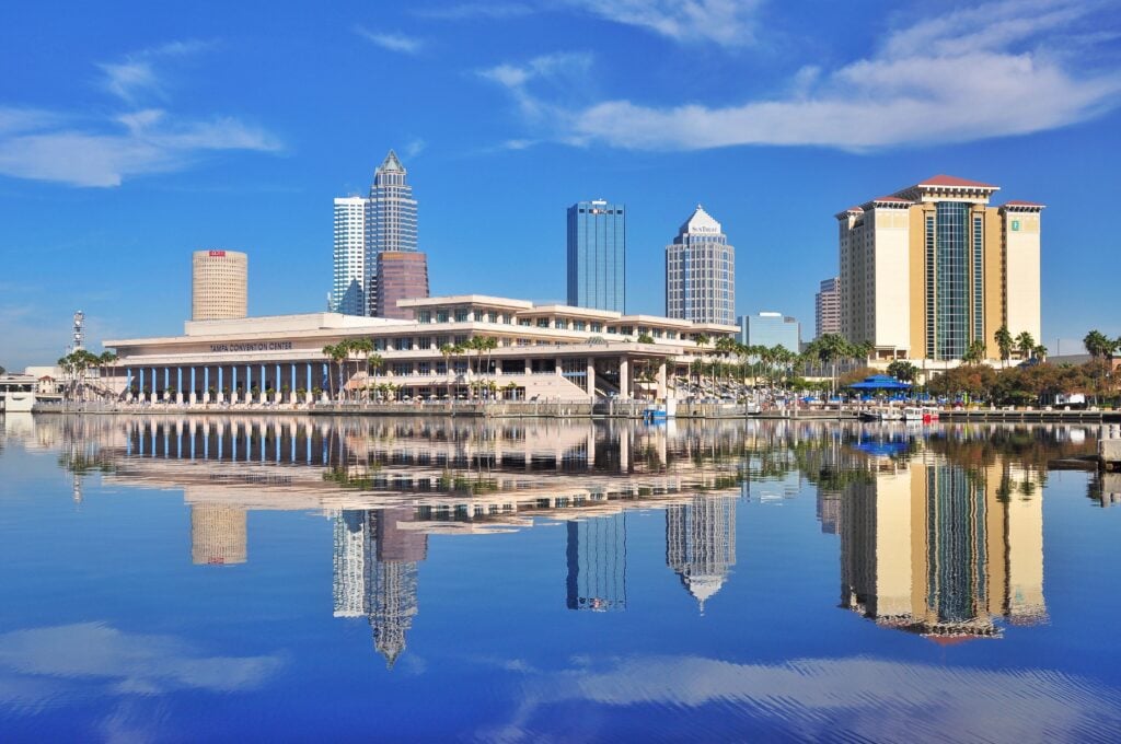Blue water reflecting the skyline of a city in Florida. Claiming Florida domicile while RVing is a good option.