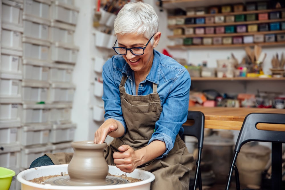 Woman working pottery on a wheel