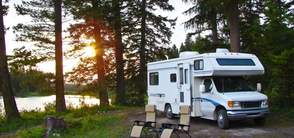class c rv setup at campsite on lake