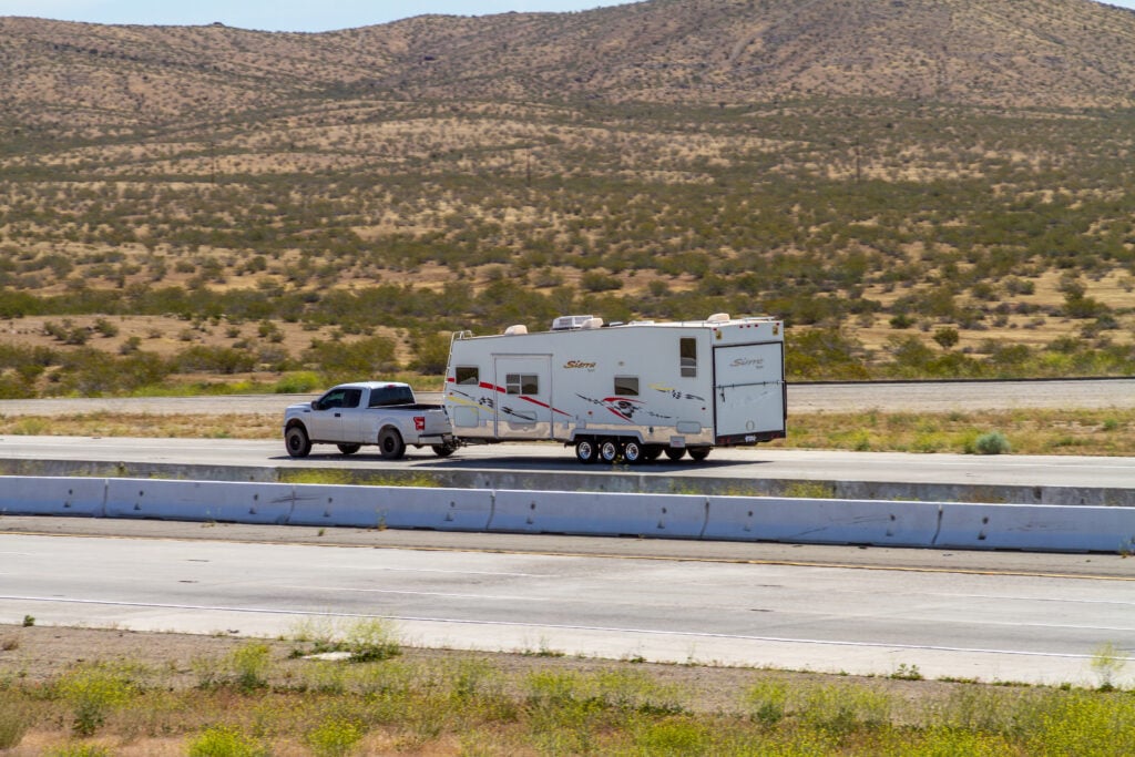 RV being towed on highway, feature image for RV driving routes