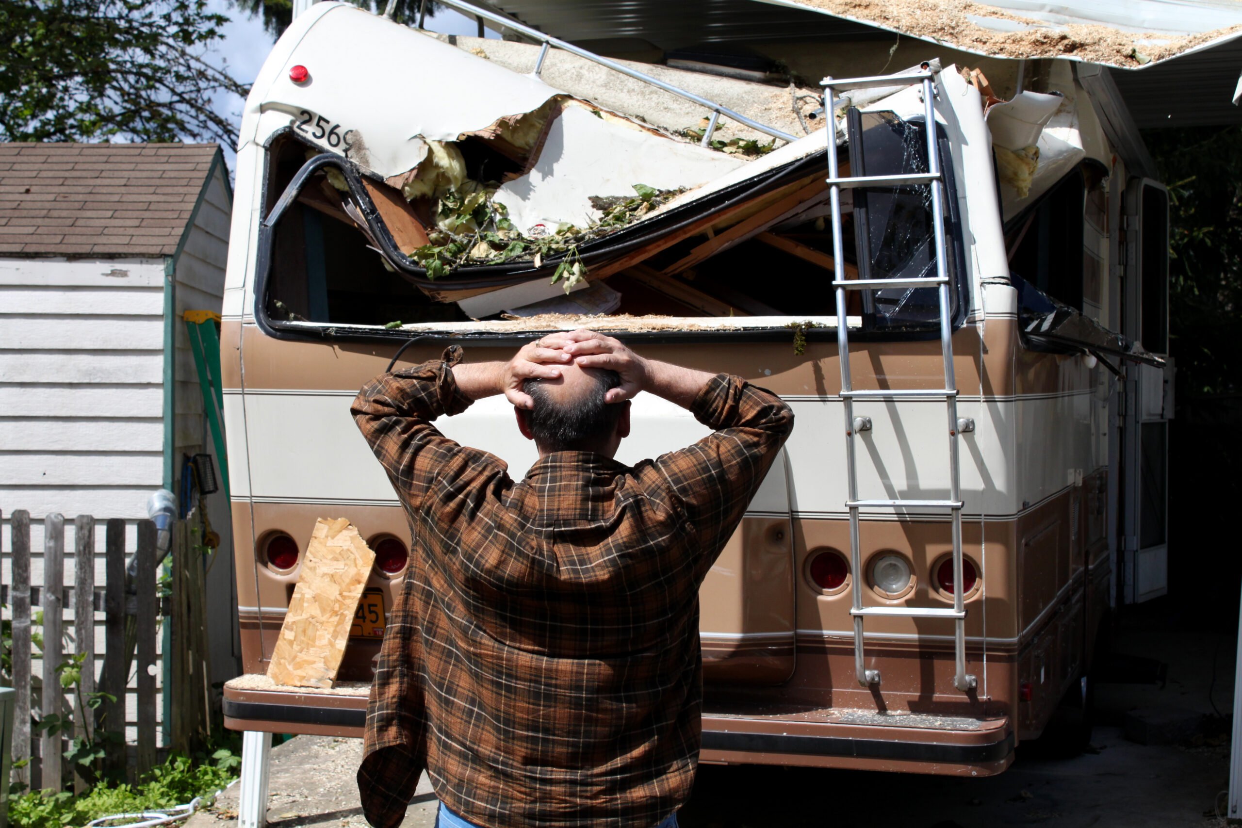 Man looking at damaged RV wondering if RV warranties or RV insurance will cover the damage