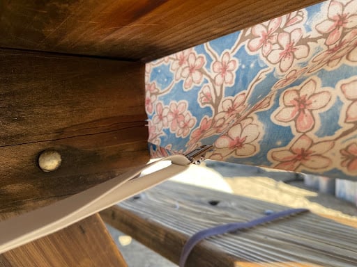 underside of a picnic table with a clamped tablecloth