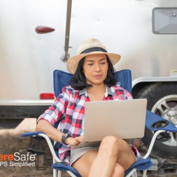 Woman uses laptop outside of Airstream camper
