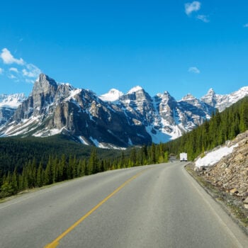 highway in Canada with mountains in distance - feature image for RV Camping in Canada