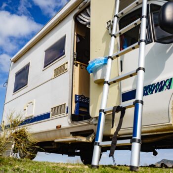RV ladder leaning on a motorhome - feature image for Winter Storage