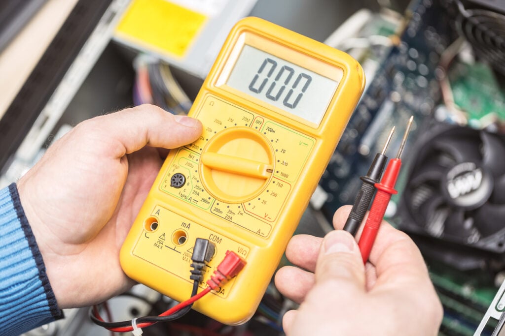 RV Technician hands holding voltmeter reading 0.00