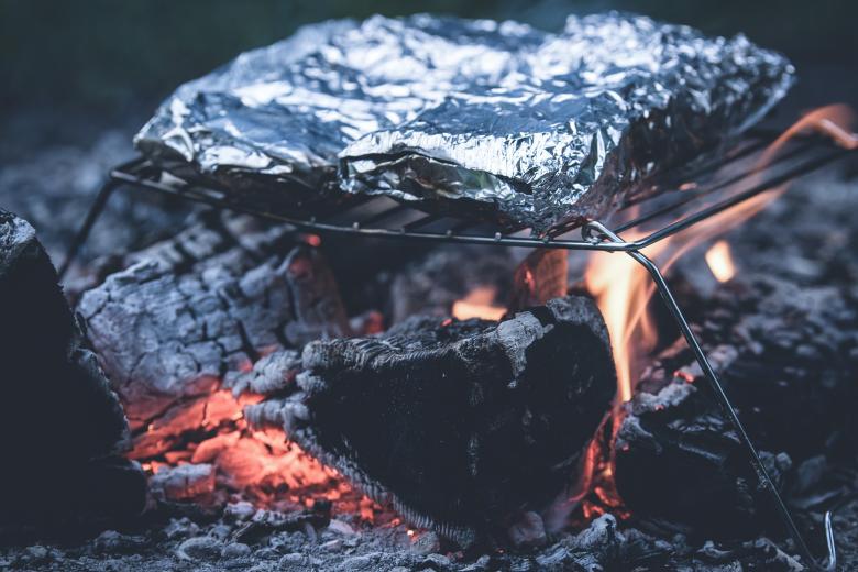 foil packet on wire grill over a fire