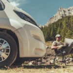 person working on computer in front of RV - feature image for full time RVing jobs