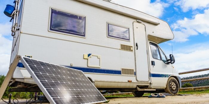 portable solar panel in front of Class C RV - feature image for Why Does My RV Battery Keep Dying