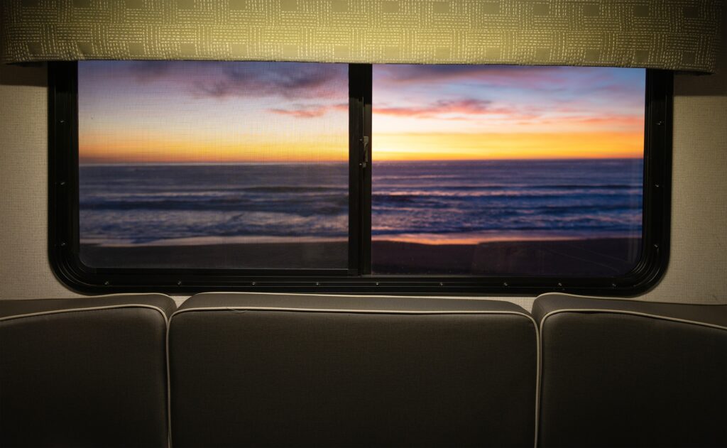 view of ocean and sunset from RV dinette bed