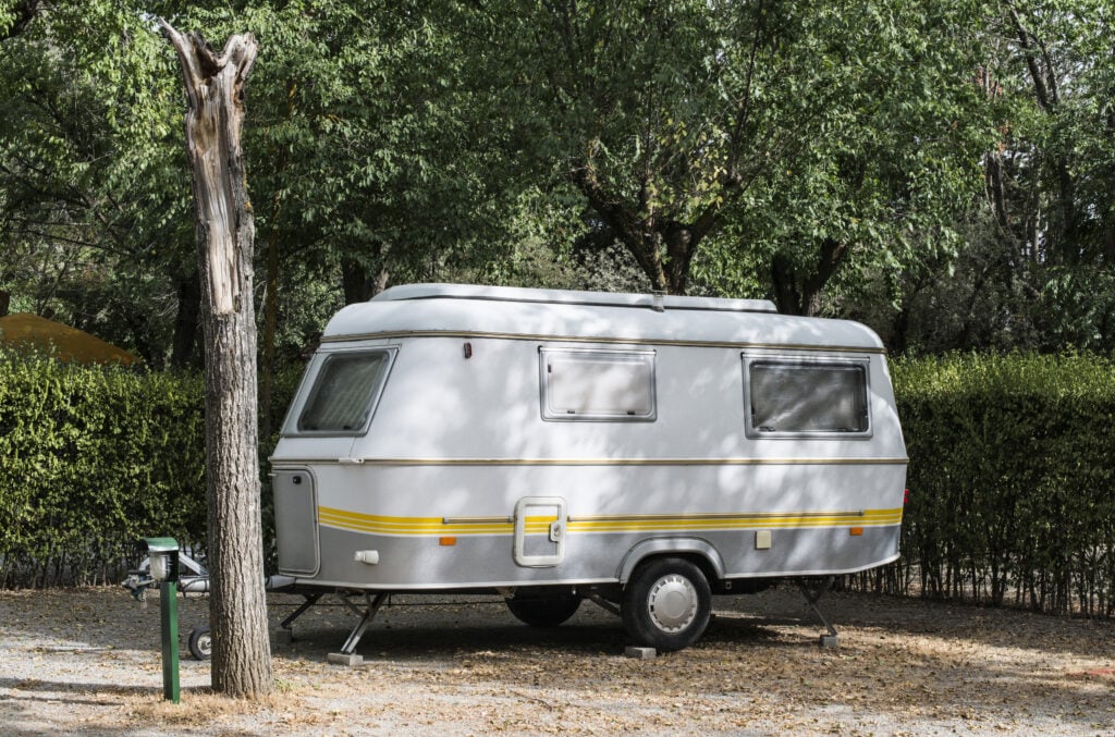 Small travel trailer parked in a small campsite - feature image for what length RV should I buy?