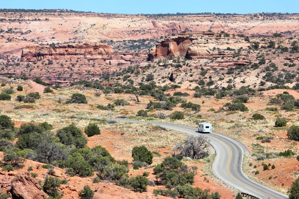 RV driving on road in Utah - feature image for affordable RVing solutions