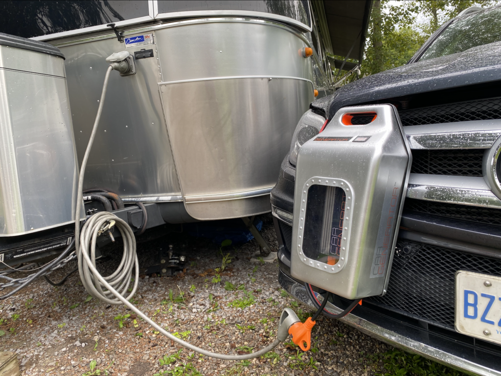 CarGenerator mounted to the front of a vehicle parked beside an Airstream used as an alternative power source
