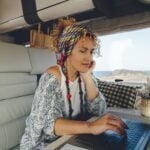 Woman with laptop works remotely form inside an RV