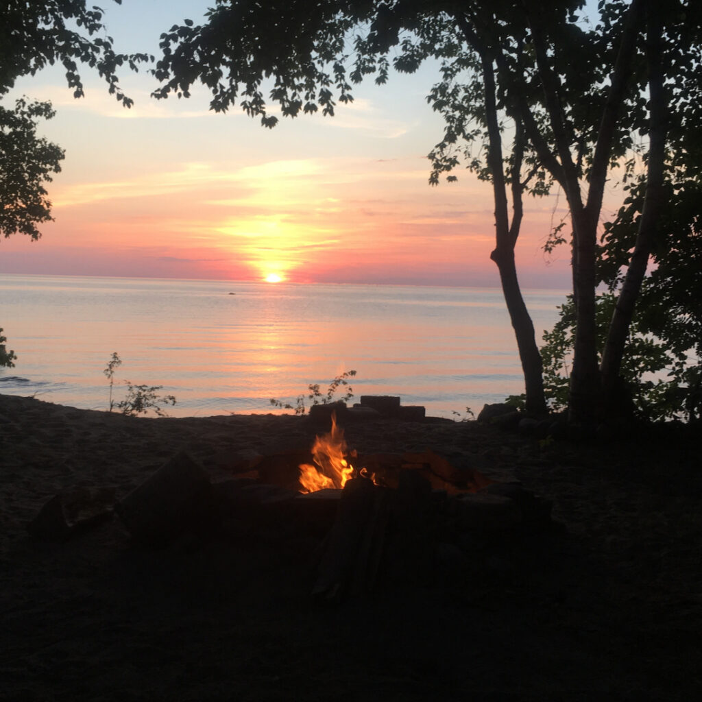 campfire at sunset over lake
