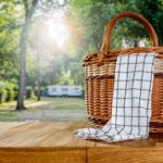 a picnic basket on a wooden table in a campground