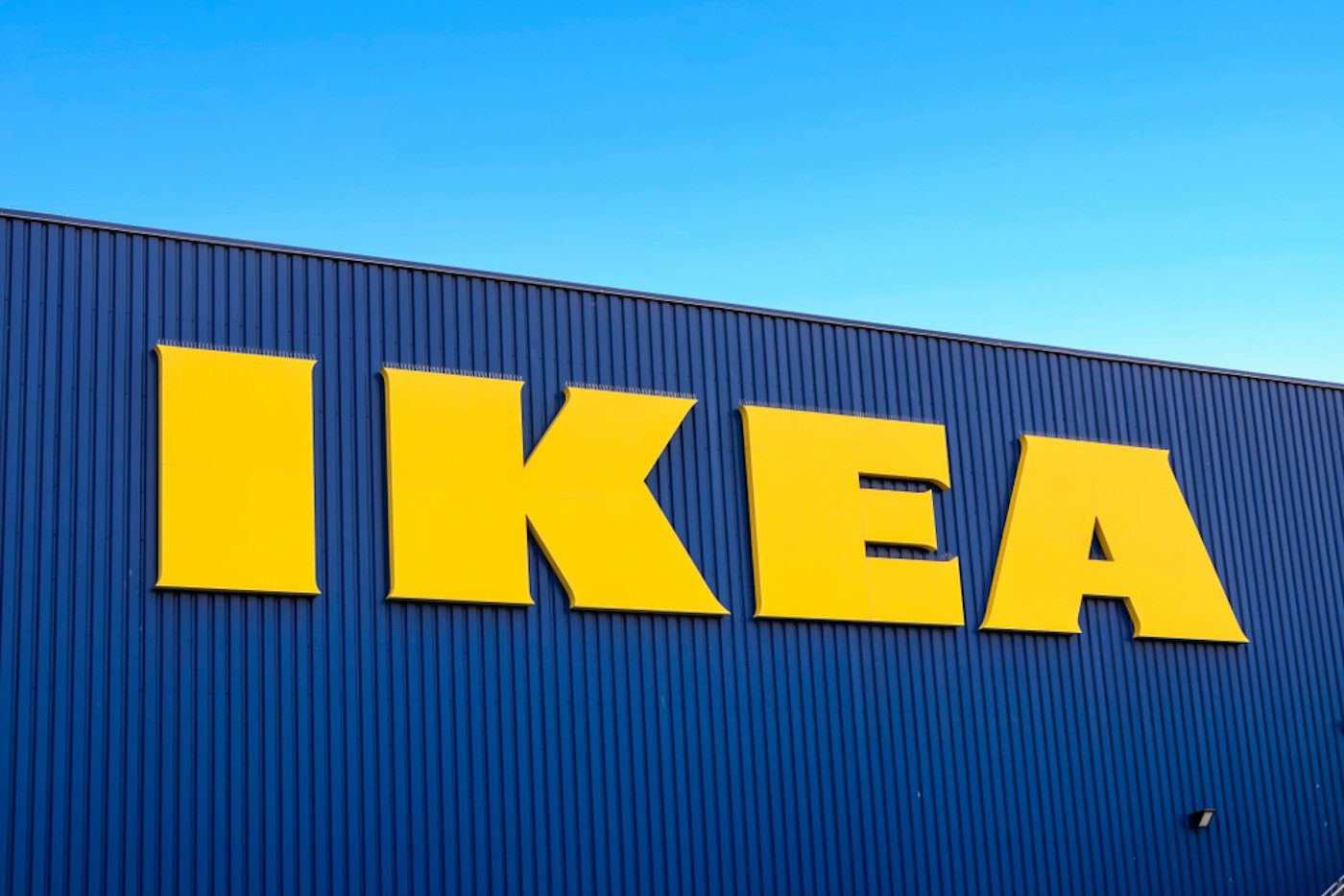 Yellow IKEA sign on blue building with blue sky in background